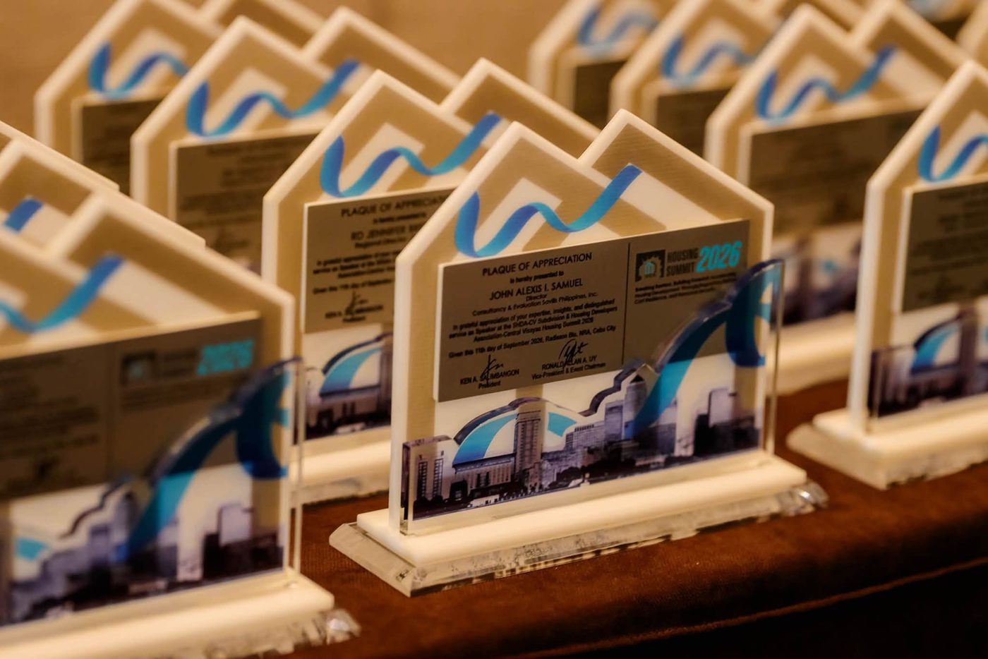House-shaped plaques of appreciation with a printed city skyline and engraved silver citation plates