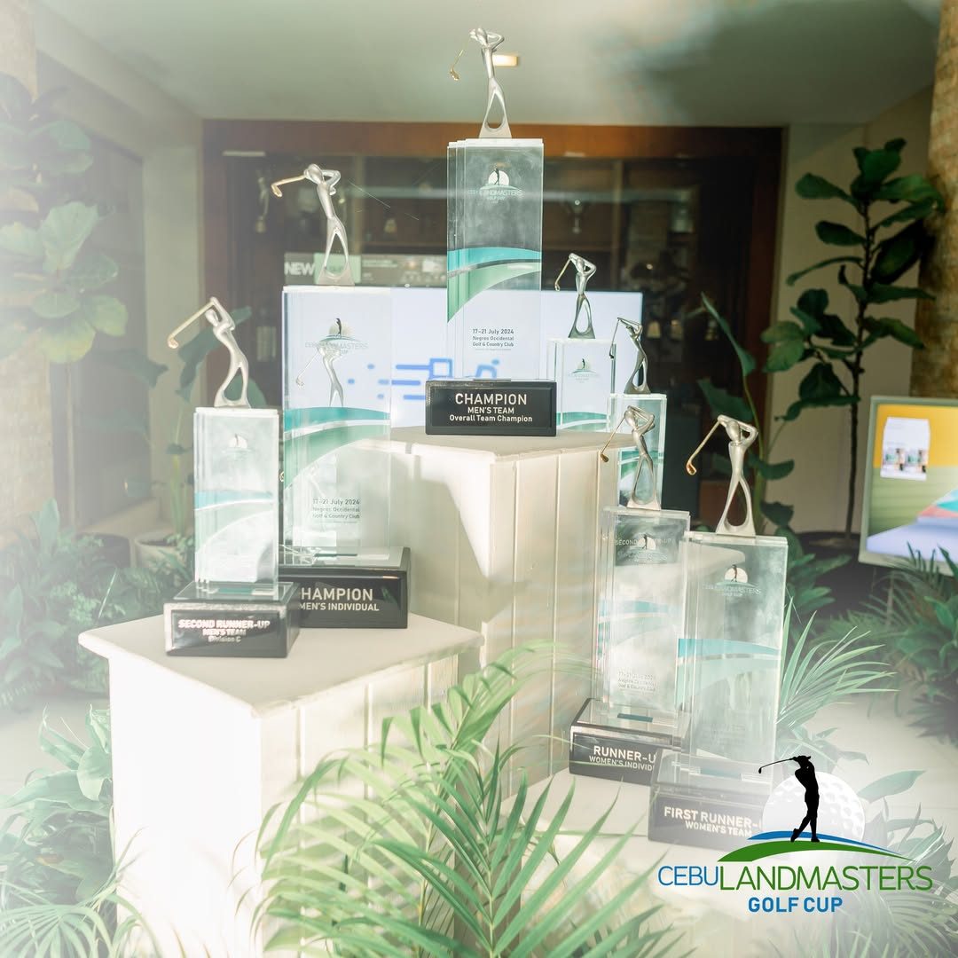 Clear trophies topped with silver golfer figures, displayed on white pedestals